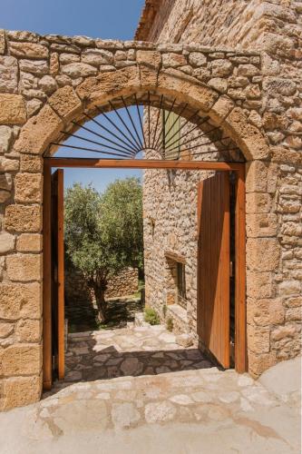 an entrance to a stone building with an open door at Kyparissia Old Town Lodge with amazing sea view in Kyparissia