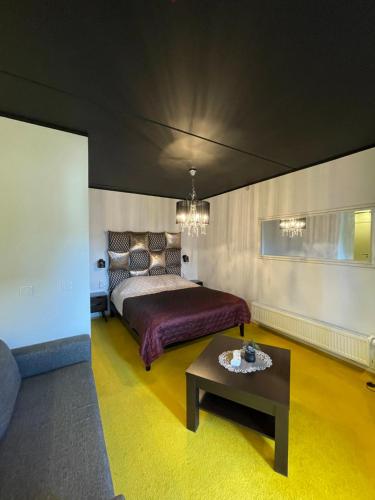 - une chambre avec un lit et une table basse dans l'établissement Guest House Bermuuda Apartment, à Paide