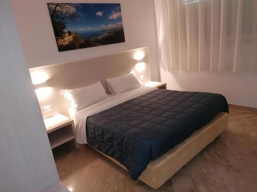 a bedroom with a large bed with two night stands at Zibibbo Beach Apartments - Trapani in Trapani