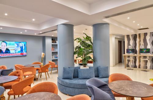 ein Wartezimmer mit Tischen und Stühlen in der Unterkunft Phidias Piraeus Hotel in Piräus