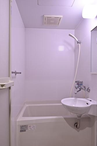 a white bathroom with a sink and a bath tub at Corner6 in Kyoto