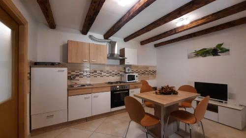 a kitchen with white cabinets and a table with chairs at Holiday Home Benny in Crikvenica