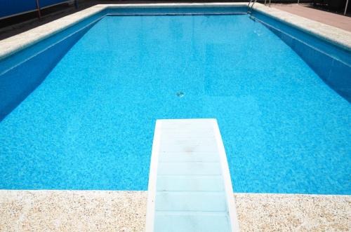 Una gran piscina azul con una escalera. en Golive Pepita en Cambrils