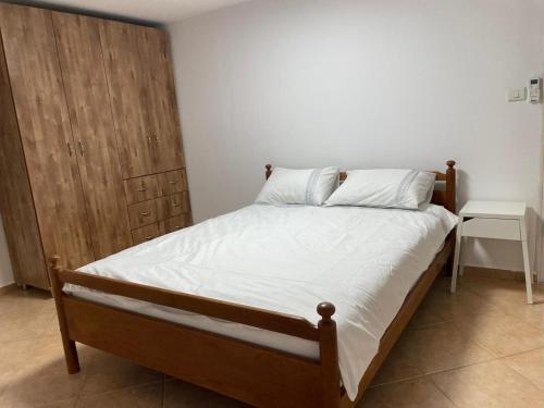 シアー・ヤーチャブにあるאל מול חרמון- דירה באווירה כפרית עם נוף לחרמוןのベッドルーム1室(ベッド1台付)、木製キャビネットが備わります。