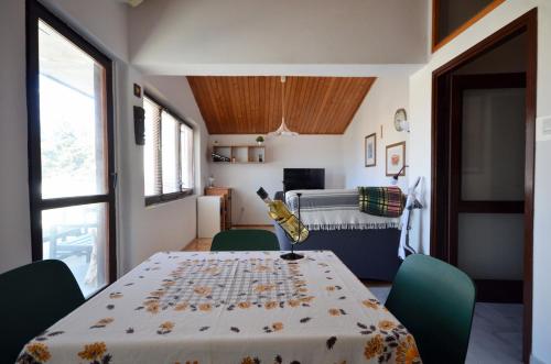 een eetkamer met een tafel en groene stoelen bij Blue Sky Apartment Primosten in Primošten