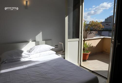 a bedroom with a white bed and a balcony at Up Hotel in Naples