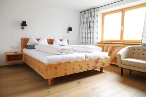 ウムハウゼンにあるBio Apartment - Der Steinadlerのベッドルーム1室(白い枕の木製ベッド1台付)