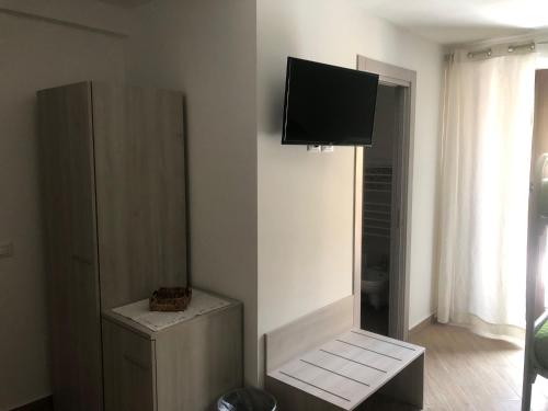 een woonkamer met een flatscreen-tv aan de muur bij LA CASA DEL BORGO in Petralia Soprana