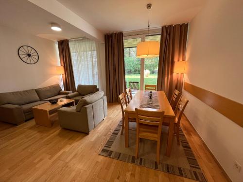 uma sala de estar com uma mesa e um sofá em Golden Fox Apartment Pohorje em Maribor