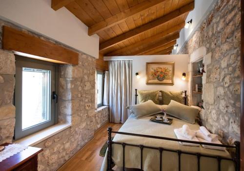 a bedroom with a large bed in a stone wall at La casa di Bella a tradional stone house with barbecue in Kariá