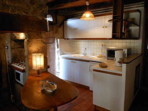 małą kuchnię z drewnianym stołem i lampką w obiekcie Gîte de Chapelèche Les Châtaigniers w mieście Gluiras
