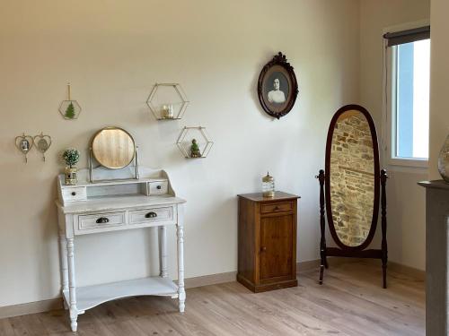 Zimmer mit einem Waschtisch, einem Spiegel und einem Tisch in der Unterkunft La Bohème Vannes, Penty centre ville proche gare in Vannes