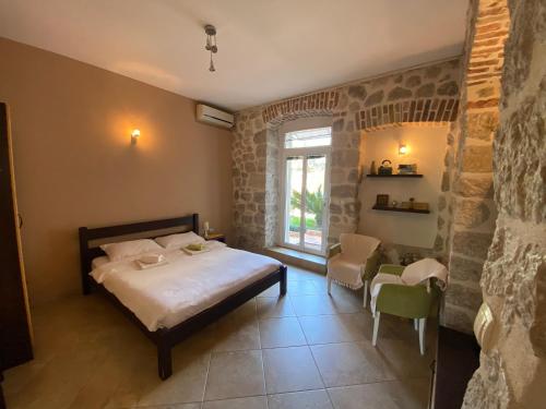 1 dormitorio con 1 cama, mesa y sillas en Apartments Marilu, en Kotor