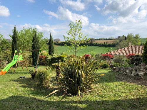 un jardín con parque infantil y columpio en Suite indépendante au cœur d’un jardin arboré., en Montaut