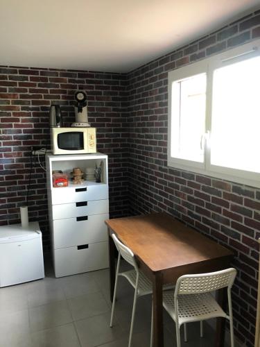 cocina con mesa de madera y microondas en Suite indépendante au cœur d’un jardin arboré., en Montaut