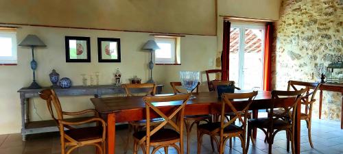 a dining room with a wooden table and chairs at maison d'hôtes Le Courty in Blousson-Sérian