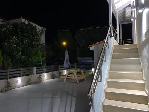 a patio at night with a table and stairs at Casa Mariei in Skala Kallirakhis