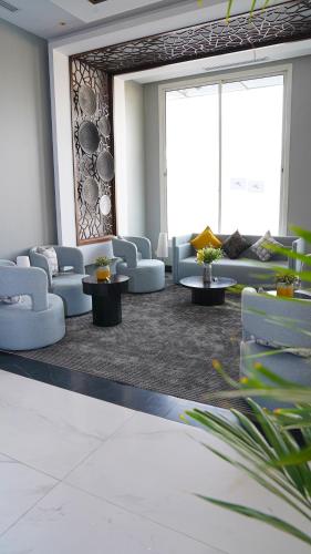 a waiting room with couches and tables and windows at Clowzer Hotel in Riyadh