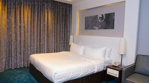 a hotel room with a bed and a chair at Clowzer Hotel in Riyadh