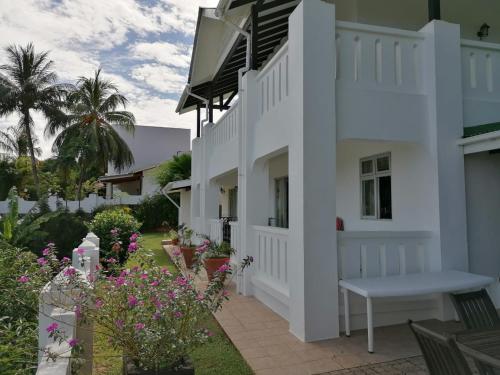 a white house with a courtyard with flowers at Bottle Palm Villa in Victoria