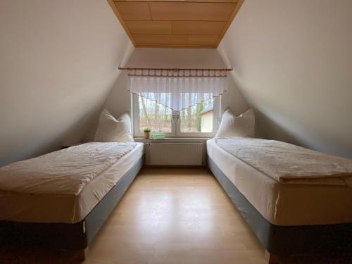 two beds in a room with a window at Ferienhaus Spreewald in Luckau