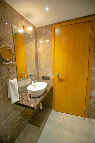 a bathroom with a sink and a wooden door at Zip By Spree Hotels Chakan, Pune in Pune