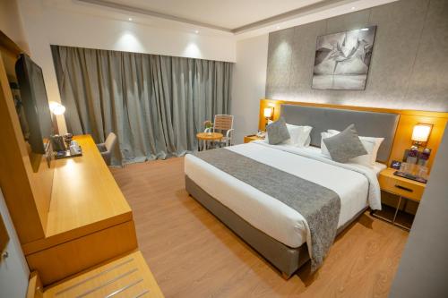 a hotel room with a large bed and a desk at Zip By Spree Hotels Chakan, Pune in Pune