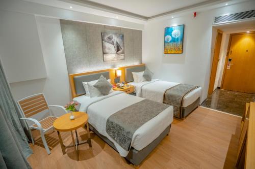 a hotel room with two beds and a table at Zip By Spree Hotels Chakan, Pune in Pune