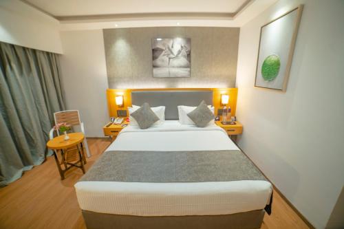 a hotel room with a bed and a table and chairs at Zip By Spree Hotels Chakan, Pune in Pune