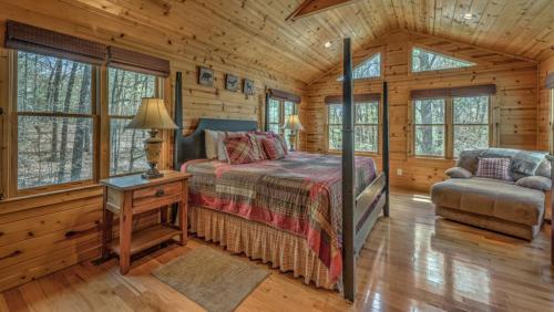 una camera da letto in una baita di tronchi con un letto e una sedia di Tranquility a Blue Ridge