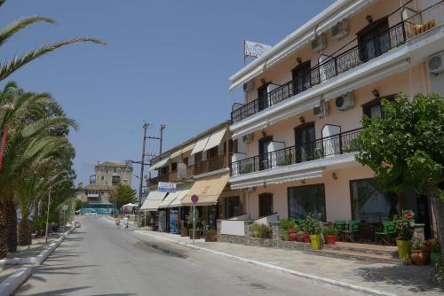 an empty street with palm trees and a building at Hotel Akrogiali in Ouranoupoli