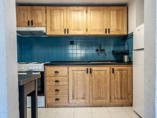 - une cuisine avec des placards en bois et un évier dans l'établissement Olea House, à Amoliani