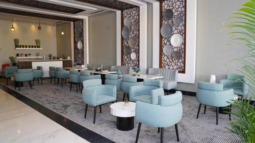 a restaurant with blue chairs and tables in a lobby at Clowzer Hotel in Riyadh