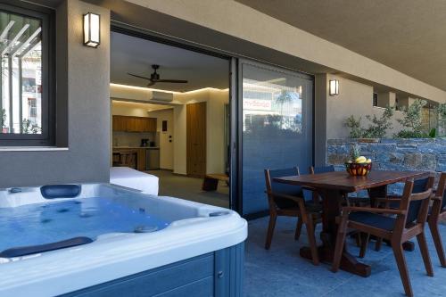 a room with a bath tub and a table with chairs at Utopia Luxury Suites in Platanes