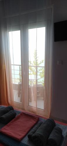 a bedroom with a large window with a view of a balcony at Ilio Socrates in Skala Marion