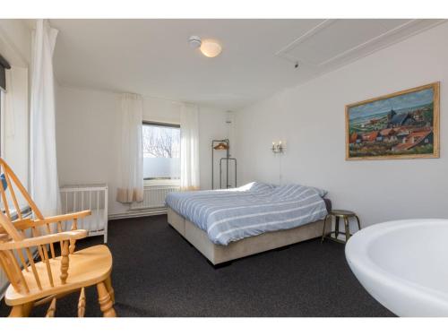 ザウテランデにあるHoliday Home Zoutelande near Beachのベッドと浴槽と洗面台のある寝室