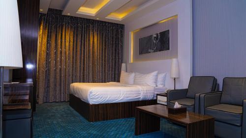 a hotel room with a bed and a chair at Clowzer Hotel in Riyadh
