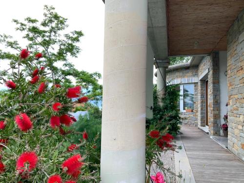 a building with red flowers on a porch at VILLA mandala in Ankaran