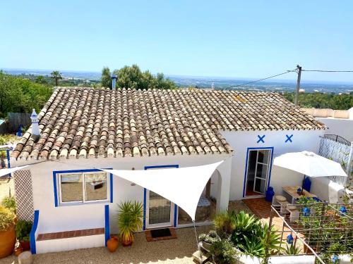 a white house with a brown roof at Casa da Aldeia in Santa Bárbara de Nexe