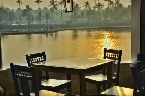 a table and chairs with a view of a river at Vala House in Cherai Beach