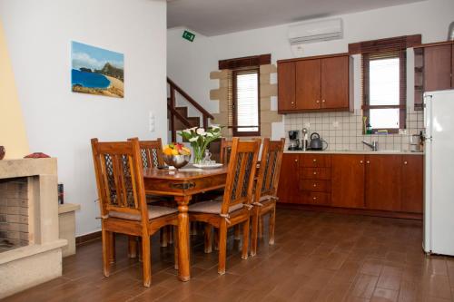 una cucina con tavolo, sedie e frigorifero di Stay in Falassarna a Falasarna