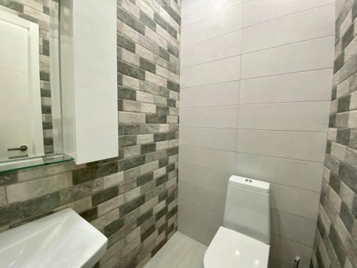 a bathroom with a white toilet and a sink at European Village Old Villa 6 in Gonio