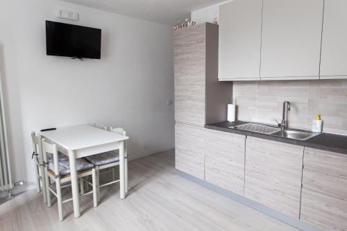 eine Küche mit einem Tisch, einer Spüle und einer Theke in der Unterkunft Appartamento Speranza in Molina di Ledro