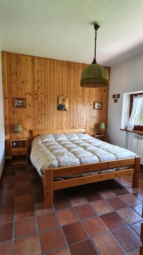 a large bed in a room with wooden walls at Dimora San Vincenzo in Pescocostanzo