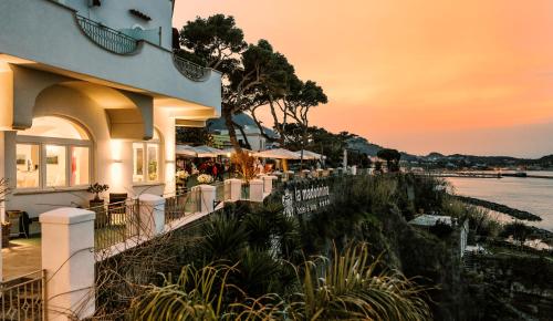 a building with a sunset in the background at Hotel La Madonnina in Ischia