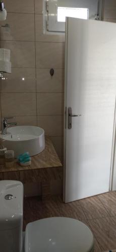 a bathroom with a white toilet and a sink at Ilio Socrates in Skala Marion