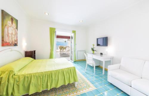 a bedroom with a bed and a couch and a desk at Hotel La Madonnina in Ischia