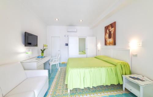 a small bedroom with a green bed and a couch at Hotel La Madonnina in Ischia