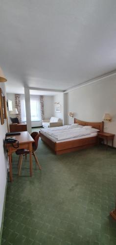 a large bedroom with a large bed and a table at Hotel Schön in Aßmannshausen