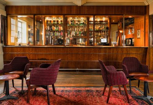 un restaurante con sillas y un bar con barra en The Aviator Hotel, en Northampton